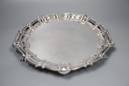 A modern circular silver salver with shell and scroll border on claw and ball feet, Birmingham,