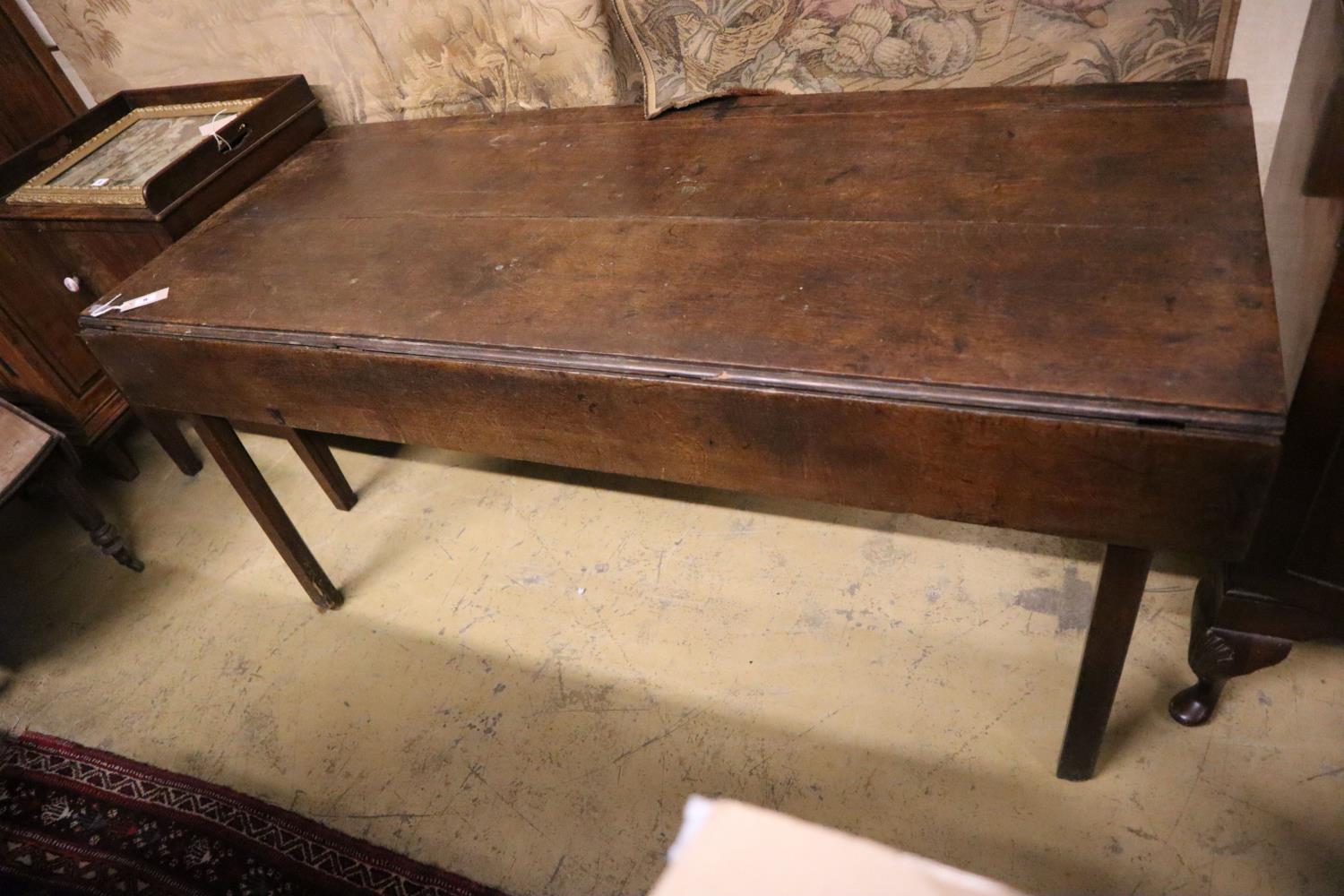 An 18th century provincial oak drop flap dining table, width 155cm, depth 66cm, height 71cm