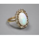 An early to mid 20th century 18ct, white opal and diamond set oval cluster ring, size K, gross 3.1