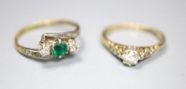 An 18ct and plat, emerald and diamond set three stone crossover ring, with diamond set shoulders,