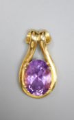 A modern yellow metal and oval cut amethyst set pendant, 31mm, gross 9 grams.