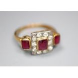 An early 20th century yellow metal, ruby and diamond cluster ring with ruby set shoulders, size K,