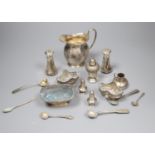 A George V silver cream jug and a collection of small silver and plated condiments and spoons.