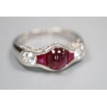 A modern white metal (possibly platinum?), synthetic? ruby and diamond dress ring, set with cabochon