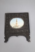 A 19th century Indian oil on ivory miniature, The Qutub Minar Tower, 6.5cm wide, in a carved ebony