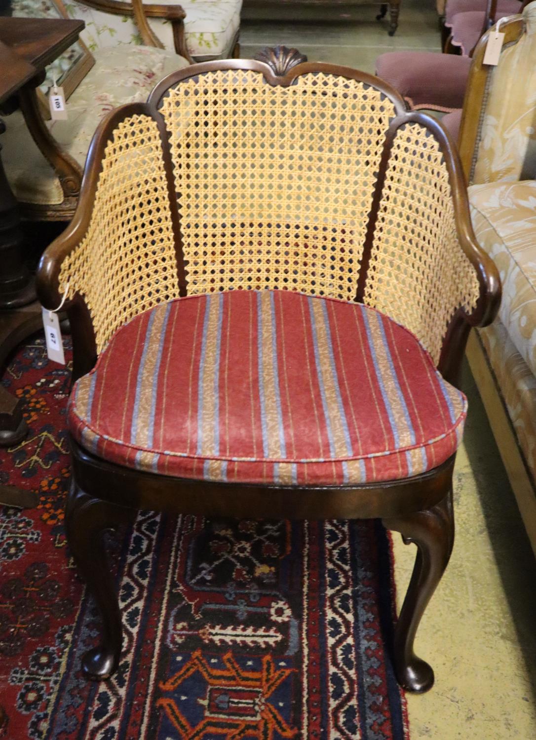 A 1920's Georgian style mahogany bergere with caned sides and cabriole legs