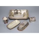 A pair of silver plated entree dishes with covers and handles, a plated butter dish, two condiments,