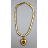 A Victorian yellow metal snakelink mourning bracelet, hung with a garnet set heart shaped charm with