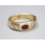 A yellow metal and gypsy set ruby and diamond three stone ring, size U/V, gross 8.9 grams.