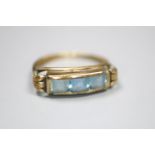 A 333 (8ct) yellow metal and channel set three stone blue topaz? ring, size J, gross 1.4 grams.