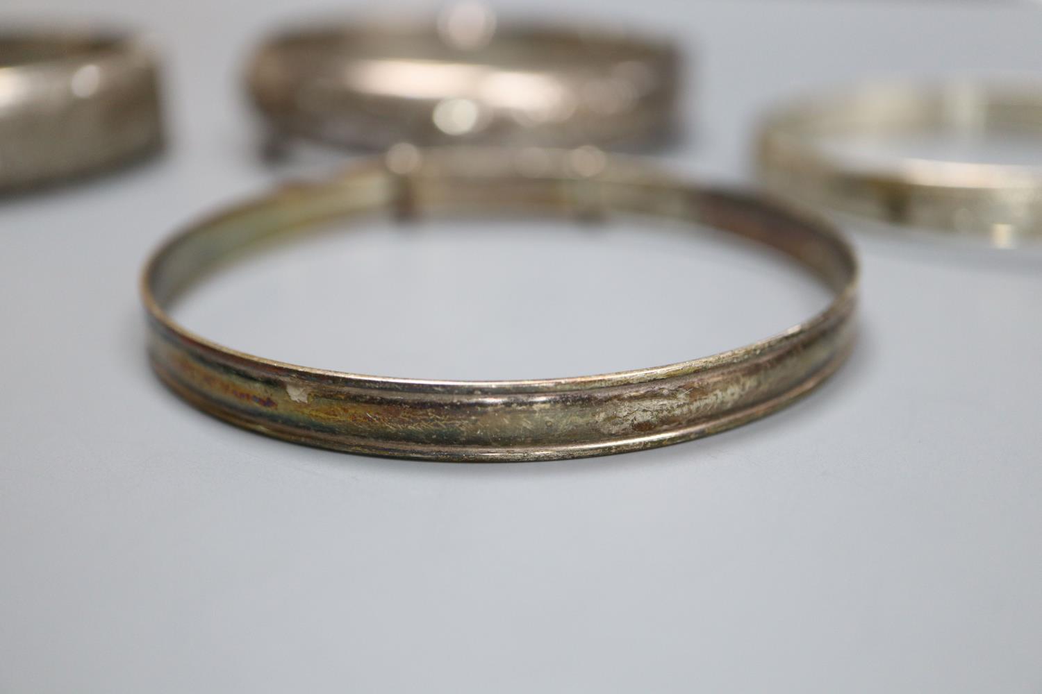 Four assorted silver bangles and a gold plated bangle. - Image 3 of 5