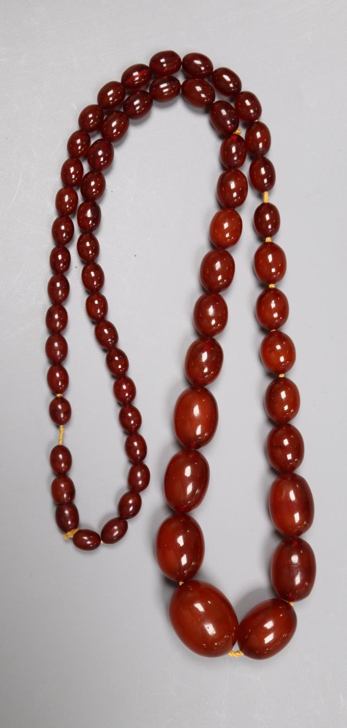 A single strand graduated oval simulated amber bead necklace, 80cm, gross 70 grams. - Image 2 of 2