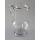 A Georgian plain baluster glass jug, 18th century, with applied scrolled handle and spreading