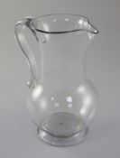 A Georgian plain baluster glass jug, 18th century, with applied scrolled handle and spreading