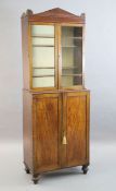 A Regency mahogany collector's cabinet, with architectural cornice and two glazed doors over two