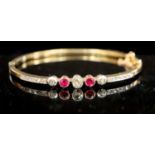An Edwardian gold, ruby, old and rose cut diamond set hinged bracelet, with safety chain, gross 9.