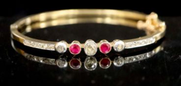 An Edwardian gold, ruby, old and rose cut diamond set hinged bracelet, with safety chain, gross 9.