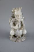 A Chinese grey jade figure, the stylised figure with wings and ribbon tied hair, in a crouching