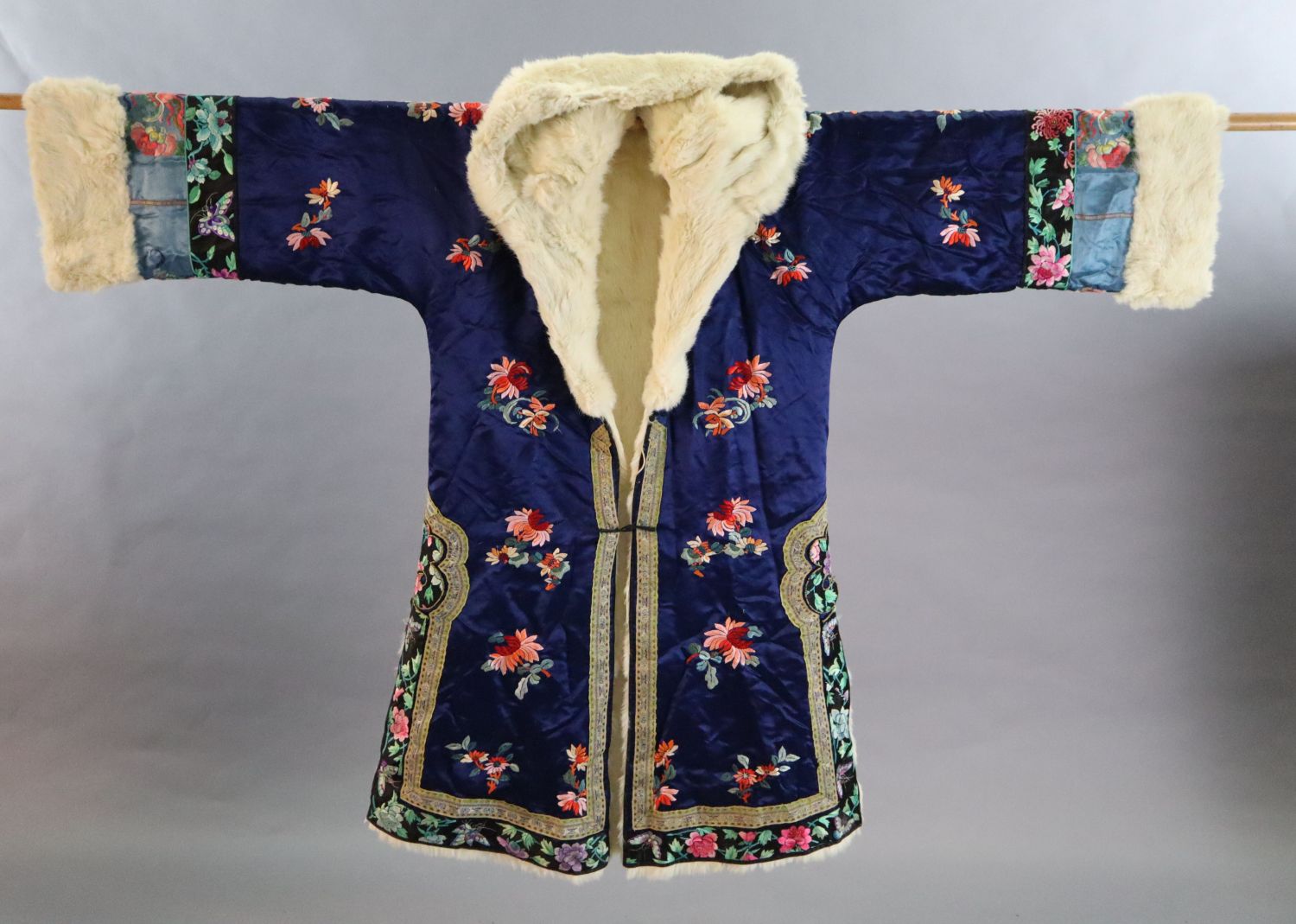 A Chinese blue silk multicoloured embroidered Chinese winter robe, early 20th century, with a