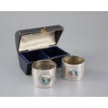 A cased pair of Edwardian Art Nouveau silver and enamel napkin rings, by William Hair Haseler,