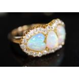 A gold, three stone white opal and diamond set cluster ring, with two heart shaped opal and one oval