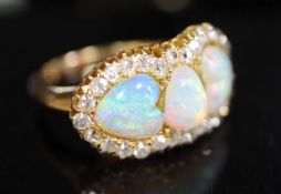 A gold, three stone white opal and diamond set cluster ring, with two heart shaped opal and one oval