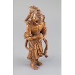 A fine Japanese boxwood okimono of the Sennin Handaka Sonja with a dragon clambering on his back,