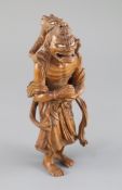 A fine Japanese boxwood okimono of the Sennin Handaka Sonja with a dragon clambering on his back,