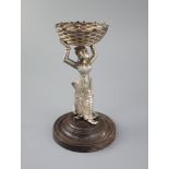 A 19th century Burmese engraved silver figural table salt, modelled as a lady holding a basket above