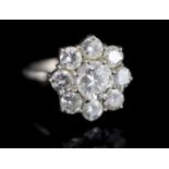 A 1970's 18ct white gold and nine stone diamond cluster ring, size L, gross 6.1 grams, the central