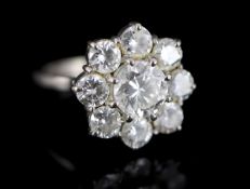 A 1970's 18ct white gold and nine stone diamond cluster ring, size L, gross 6.1 grams, the central