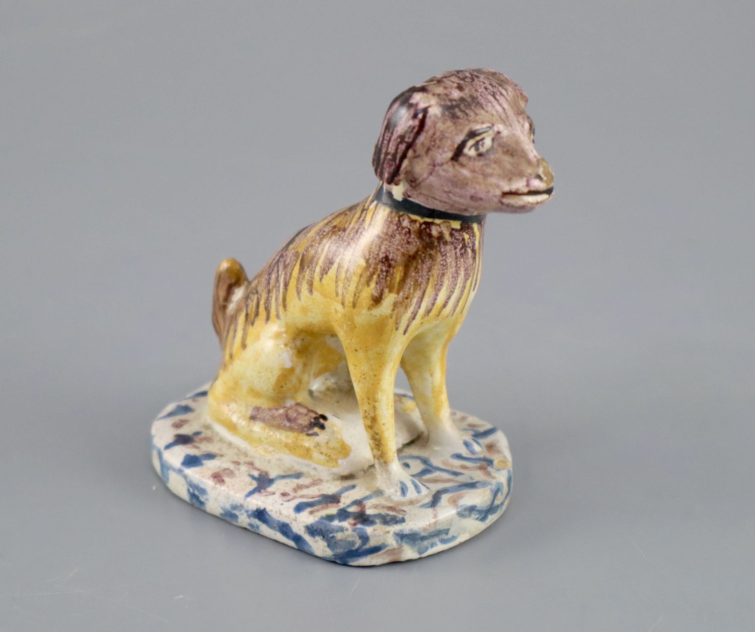 A Continental faience model of a seated dog, mid 18th century, possibly Brussels,CONDITION: