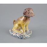 A Continental faience model of a seated dog, mid 18th century, possibly Brussels,CONDITION: