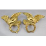 A pair of early 19th century carved giltwood and gesso wall appliqués, each modelled as a winged