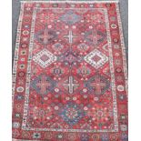 A Bakhtiari red ground carpet circa 1900, with field of geometric motifs and three row border,