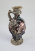 A Roman amethyst glass ewer, 1st/2nd century AD, mould blown in the form of a head with applied