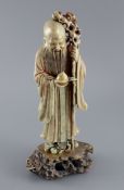 A Chinese soapstone figure of Shou Lao, 18th century, holding a gilt peach in his right hand and a