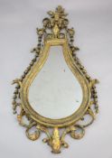 An early 19th century giltwood and gesso wall mirror, tear drop shaped with urn, flower and bell