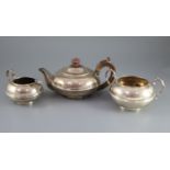 A George V silver three piece tea set by Heming & Co, of squat circular form, with banded girdle,