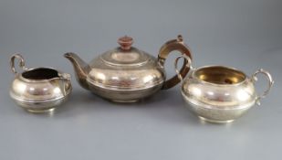 A George V silver three piece tea set by Heming & Co, of squat circular form, with banded girdle,