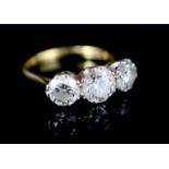 A modern 18ct gold and three stone brilliant cut diamond ring, the central stone weighing