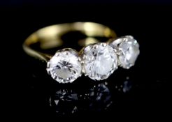 A modern 18ct gold and three stone brilliant cut diamond ring, the central stone weighing