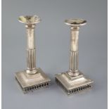 A pair of early 19th century Spanish silver candlesticks, with demi-fluted stems, on square bases,