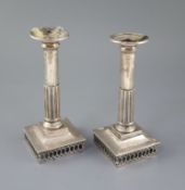A pair of early 19th century Spanish silver candlesticks, with demi-fluted stems, on square bases,