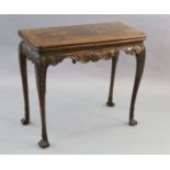 A mid-18th century Irish carved walnut folding top card table, with scallop and scroll carved