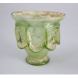 A Roman green glass 'auricular' cup, 2nd/3rd century AD, the funnel shaped body with applied '