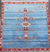 An Iranian Qushqa'i Gabbeh blue ground carpet, with central geometric motif and single row border,