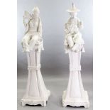 A pair of Continental tin glazed pottery figures of a Chinese man and woman, seated upon a bell-