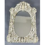 A 19th century Dieppe ivory wall mirror, of arched rectangular form with oval plate, applied with