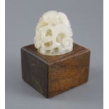 A Chinese white jade hat finial, carved in high relief and openwork with scrolling leaves and